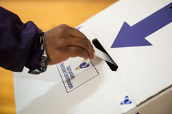 Hand placing ballot paper in ballot box